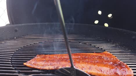 Flipping-a-salmon-steak-over-on-the-barbecue-grill---isloated-slow-motion