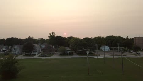 Smokey-sunset-visible-over-a-midwestern-neighborhood-in-an-early-evening,-no-person