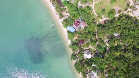 Toma-Vertical-Aérea-De-Una-Playa-Turística-En-Koh-Chang-Con-Tejados,-Resorts-De-Mar-Y-Bungalows