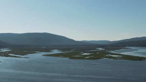 Ruhige-Landschaft-Am-Saint-Lawrence-River-In-Quebec,-Kanada-Mit-Nebligen-Bergen-Im-Hintergrund---Langsamer-Schwenk