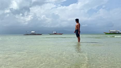 Junger-Tourist,-Der-Tropischen-Strand-Voller-Bangka-boote-Bewundert---Philippinen-Reisen-Und-Reiseziele