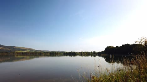 Panoramic-view-from-the-shore-of-Loch-Leven-Kinross-across-to-bishop-hill-with-very-calm-and-reflective-water