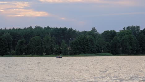 Gente-Montando-Un-Bote-De-Remos-Cisne-Y-Disfrutando-Del-Tranquilo-Lago-En-El-Parque-Paisajístico-Wdzydze-Durante-La-Puesta-De-Sol-En-El-Norte-De-Polonia