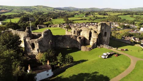 Welsh-medieval-landmark-Denbigh-Castle-medieval-old-hill-monument-ruin-tourist-attraction-aerial-rising-view-across-countryside