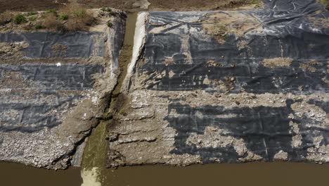 Aerial-shot-of-a-manure-lagoon-over-flow-spout-draining-into-the-next-cell