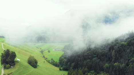 Aerial-of-Misty-Mountain-Valley-next-to-Green-Forest-with-Clouds