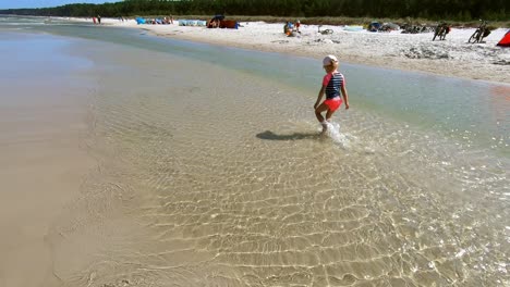 Little-Girl-Walking-Slowly-Splashing-Water-on-Beach