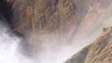 Mist-from-Yellowstone's-Lower-Falls-blows-against-cliff-face