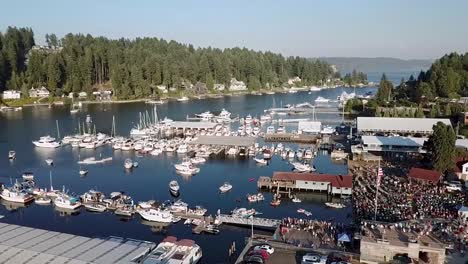 Docked-Boats-At-Gig-Harbor-Marina-And-Boatyard---Crowd-Of-People-Gather-And-Watching-Free-Outdoor-Concert-At-Skansie-Brothers-Park-And-Netshed-In-Gig-Harbor,-Washington,-USA