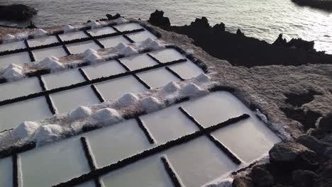 A-wide-shot-of-a-saltwork-grid-and-the-sea-next-to-it