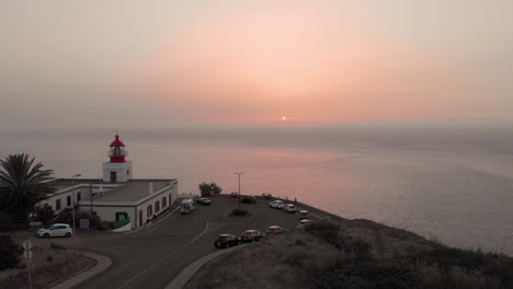 Erstaunliche-Drohnenantenne-Mit-Blick-Auf-Die-Meereslandschaft-Leuchtturm-Bei-Sonnenuntergang-Mit-Rosa-Wolken,-In-Spanien