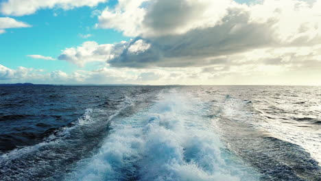 Motorboat-Speeding-And-Leaving-Wake-Across-The-Sea-On-A-Sunny-Day---Bay-Of-Islands,-New-Zealand---POV,-wide-shot