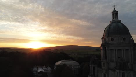 Ashton-memorial-wealthy-historic-dome-folly-landmark-aerial-view-across-sunrise-Lancashire-countryside-pull-back