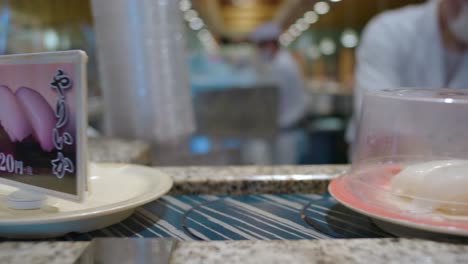 Nahaufnahme-Von-Sushi-Tellern-Auf-Einem-Sich-Bewegenden-Förderband-In-Einem-Kaiten-Zushi-Restaurant-In-Tokio,-Japan
