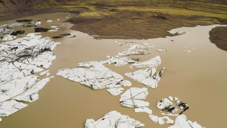 Dolly-in-aerial-shot-of-cracked-iceberg-on-the-glacier-lake-in-Fjallsárlón