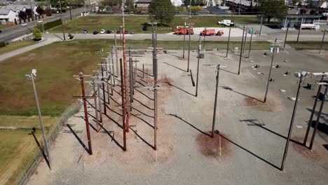 Telephone-Poles-Situated-At-The-Empty-Training-Grounds-Of-Bates-Technical-College-On-A-Sunny-Day-In-Tacoma,-Washington-State,-USA---aerial-sideway-shot