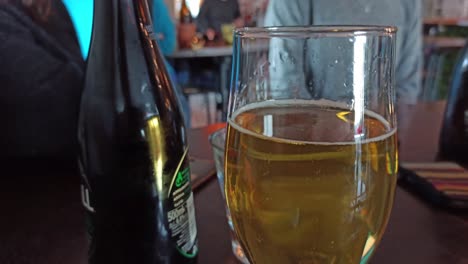 A-close-up-shot-of-a-glass-of-cider-with-people-out-of-focus-in-the-background