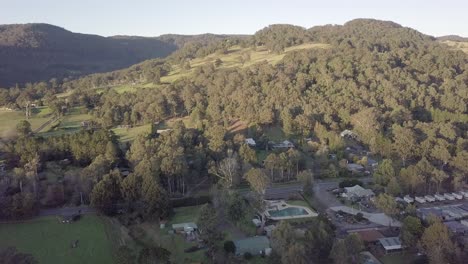 Kangaroo-Valley-Glenmack-Park-with-swimming-pool-down-below,-Aerial-pan-right-reveal-shot