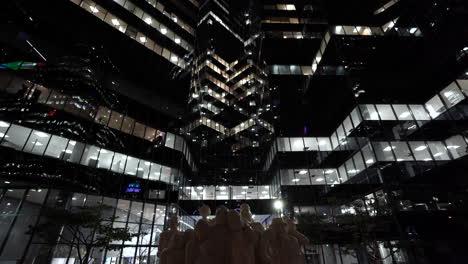 Hermoso-Paisaje-De-La-Ciudad-Por-La-Noche---Edificios-Modernos-De-La-Torre-Richter-Llp-Con-La-Escultura-De-La-Multitud-Iluminada-En-Primer-Plano-Durante-El-Coronavirus-En-El-Centro-De-Montreal,-Quebec,-Canadá