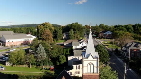 Aerial-pull-back-reveal-shot-of-old-historic-church-in-small-town-America,-United-States-establishing-shot-of-Christianity-in-USA