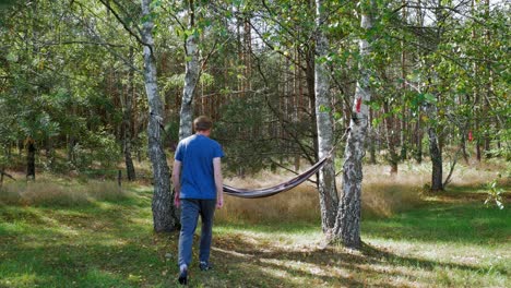 Caucasian-Man-Enjoying-And-Relaxing-In-A-Hammock-Hanged-Over-Trees-In-A-Quiet-Forest---medium-shot