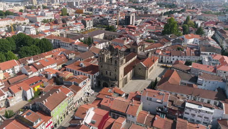 Drone-Orbiting-Over-The-Beautiful-City-Of-Braga-With-red-Roof-Buildings-And-Braga-Cathedral-On-A-Sunny-Summer-Day-In-Portugal