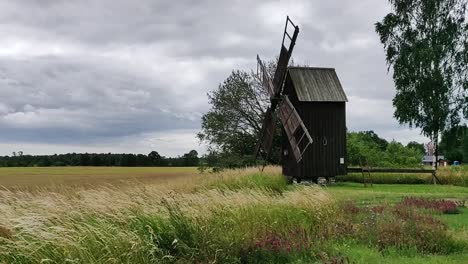 Alte-Holzwindmühle-Mit-Langem-Gras,-Das-Im-Wind-Weht