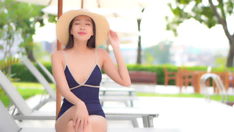 Perfekte-Asiatische-Frau-Im-Badeanzug,-Der-Am-Pool-Kühlt