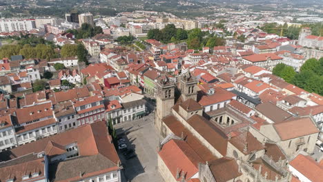 Sobrevolando-Los-Edificios-De-Techo-Rojo-En-La-Ciudad-De-Braga-Hacia-La-Histórica-Catedral-De-Braga-En-Un-Día-Soleado-En-Portugal