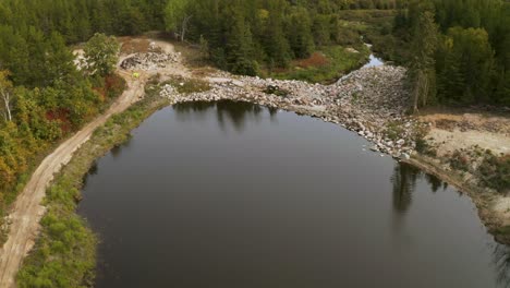 Man-made-lake-held-back-by-a-natural-looking-rock-dam