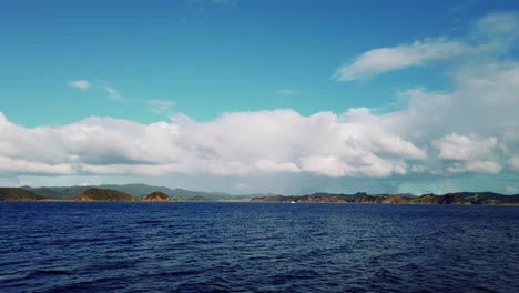 Schöne-Landschaft-Der-Insel-Am-Plätschernden-Ozean-Unter-Blauem-Himmel-Mit-Wolkengebilde---Bay-Of-Island-In-Neuseeland
