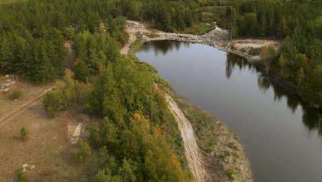 Man-made-lake-held-back-by-a-rock-dam-in-the-lush-Canadian-boreal-forest