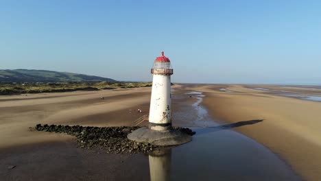 Talacre-lighthouse-North-Wales-golden-sandy-beach-shimmering-low-tide-sunrise-aerial-pull-back-orbit-right-view
