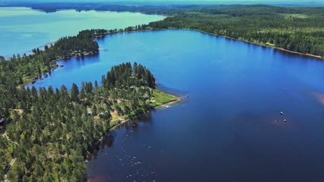 Morning-With-Beautiful-Fall-Landscape-Scenery-Of-Calm-Blue-Lake-Surrounded-By-Lush-Pine-Tree-Forests-In-Vansbro-Municipality,-Dalarna-County,-Sweden---aerial-drone