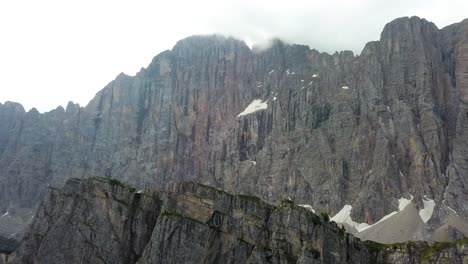 Aerial-close-up-of-a-mountain-ridge-on-a-cloudy-overcast-day-in-the-Dolomites-Italy-near-Alleghe-village