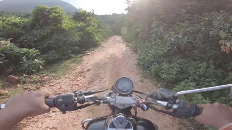 Biker-riding-offroad-in-a-dense-green-alley-riding-to-the-mountain-at-Parasnath-Hill-in-Jharkhand,-India