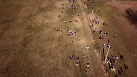 Aerial-view-of-a-group-of-people-walking-and-exercising-their-dogs-off-leash,-running-together