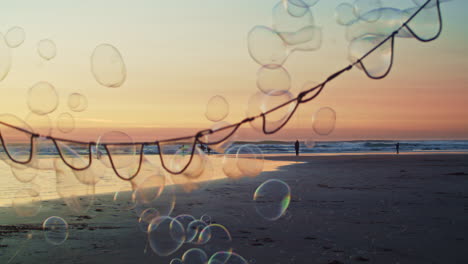 Giant-bubble-wand-floats-bubbles-over-vibrant-beach-sunset