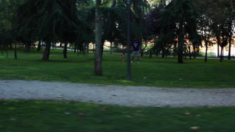 Eine-Frau-In-Sportkleidung-Und-Maske,-Die-Durch-Einen-Park-In-Madrid,-Spanien,-Läuft