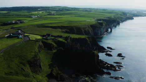 Aerial-shot-from-afar-of-a-coastline-and-the-Dunluce-Castle-in-Ireland