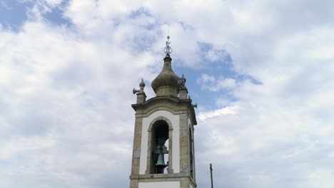 Nahaufnahme-Details-Eines-Glockenturms-Einer-Kirche-Gegen-Blauen-Himmel-Mit-Weißen-Wolken-Niedrigen-Winkel-Umkreisenden-Schuss