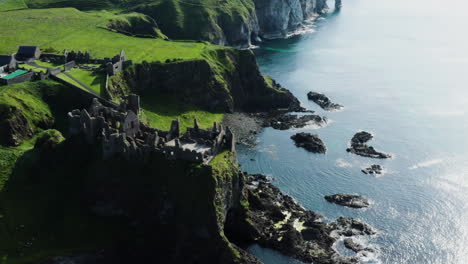Historical-Ruins-of-Medieval-Dunluce-Castle-on-Northern-Ireland-Cliff-Coast,-Aerial-Drone-Establishing