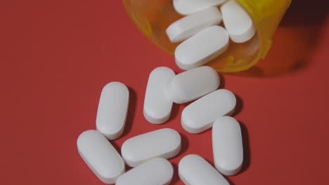 Opioidweiße-Pillen-Verschüttet-Auf-Rotem-Tisch-Gesundheitssucht-Schmerzmedizin