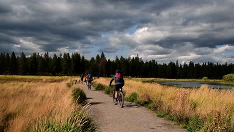 Walkers-and-bikers-on-a-trail-along-the-Deschutes-River,-Bend,-Oregon