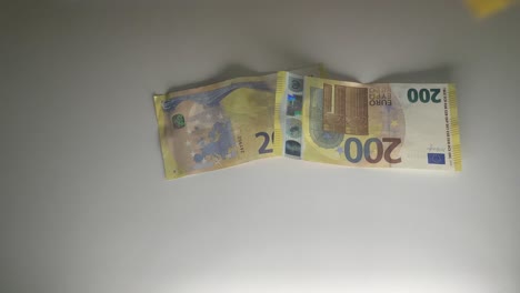 Fliegende-200-Euro-Banknoten-Auf-Einem-Weißen-Tisch