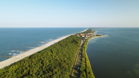 Aerial-slow-motio-straight-road-along-the-bay-and-the-sea,-clear-sky-and-cinematic-view-on-Kuznica-in-Poland