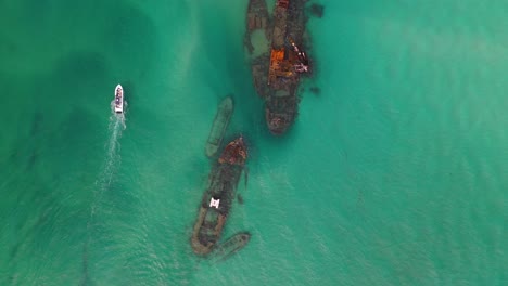 Boats-exploring-shipwrecks-off-Moreton-Island,-Australia,-aerial-top-down-view