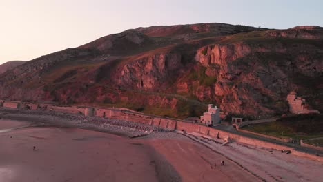Rising-drone-shot-of-the-Great-Orme-headland-in-Llandudno,-Wales-at-sunset