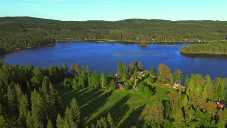 Picturesque-Landscape-Of-Calm-Lake-By-The-Lush-Green-Forest-With-Camping-Hotels-And-Picnic-Area-On-A-Sunny-Summer-Day-In-Vansbro,-Dalarna-County,-Sweden