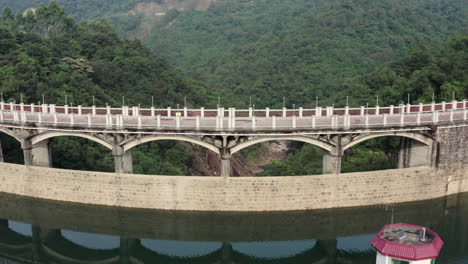 Fly-over-a-water-dam-on-a-small-mountain-river